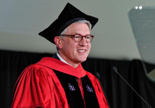 Giannobile wearing regalia speaking into microphone