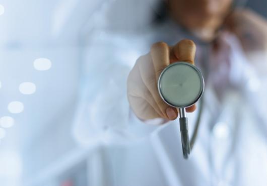 Closeup of a woman holding a stethoscope.
