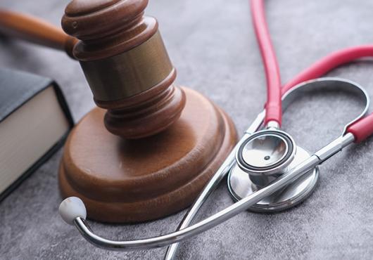 photo of stethoscope, gavel and law book
