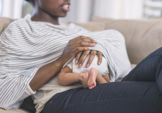 baby under woman's shirt breastfeeding