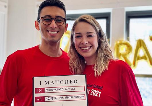 Troy Amen with his fiancee holding "I Matched" sign
