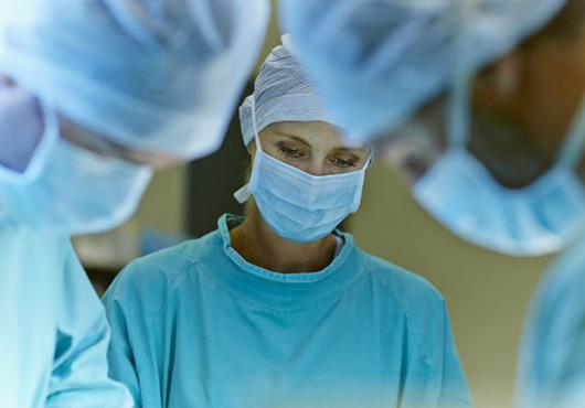 A team of masked surgeons performing surgery