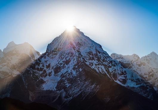 photo of mountain peak with sun shining