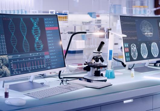 photo of a gleaming modern lab with large computer screens and microscopes
