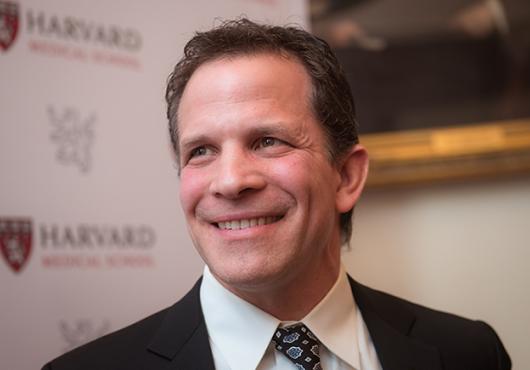 White man in suit and tie, smiling