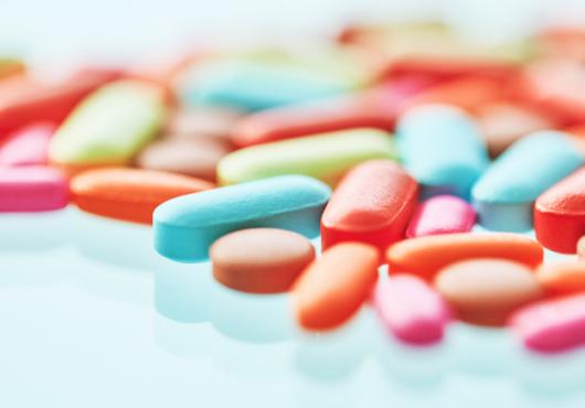 Colorful pills on a reflective surface