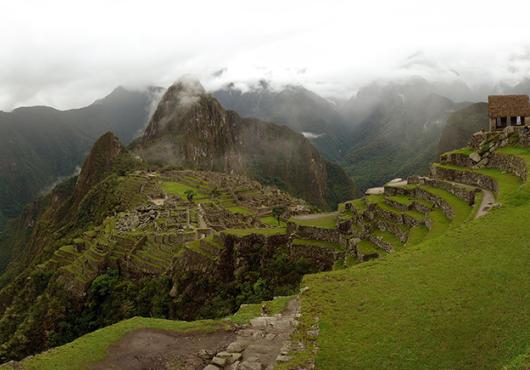 panorama of Machu Picchu site beneath cloudy sky