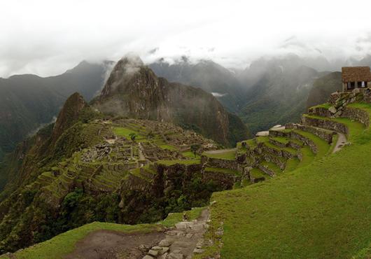 panorama of Machu Picchu site beneath cloudy skies