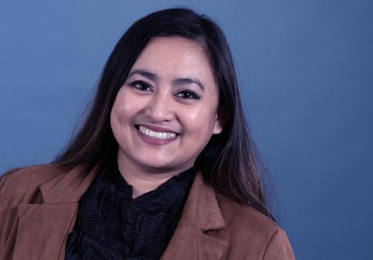 portrait photo of a smiling Filipino-American woman wearing a blazer