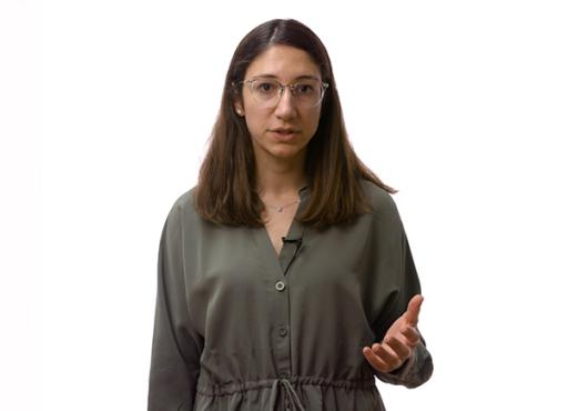 Young woman wearing glasses and a khaki jumpsuit, gesturing