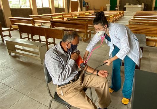 Sedas taking a patient's blood pressure reading at a community church