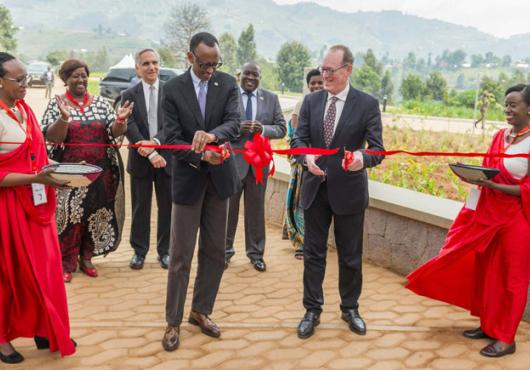 Two men cut a bright red celebratory ribbon.