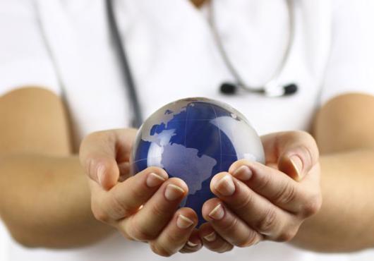 Stock image of white coated person holding a globe in hands