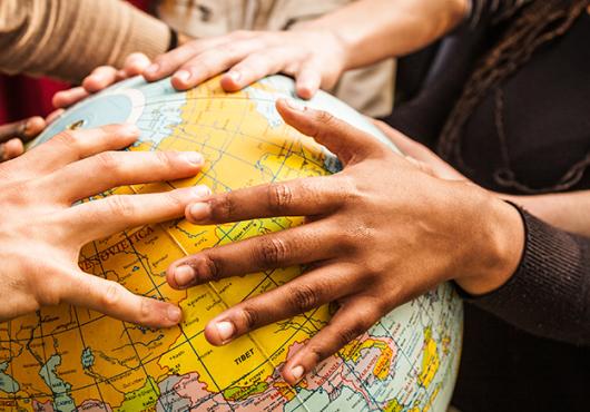 multiethnic hands on a globe