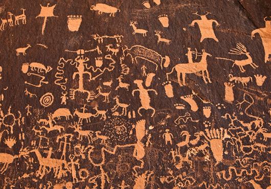 ancient cave art showing people and animals