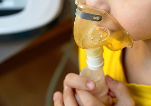 close up of child's face making an inhalation with a nebulizer