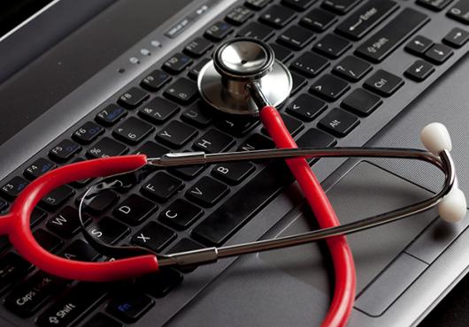red stethoscope on laptop computer 