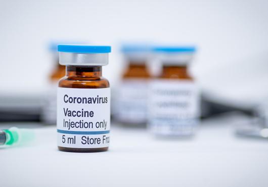photo of vials with COVID-19 vaccine label and needle