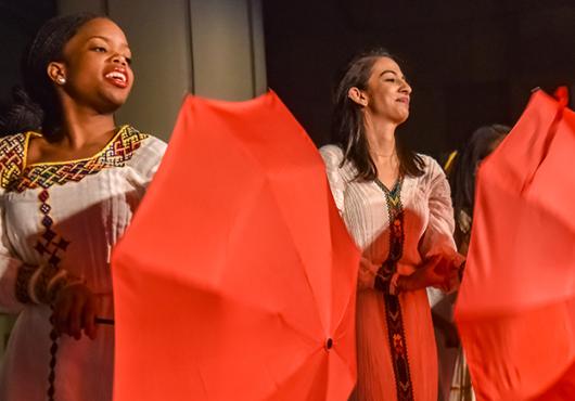 fabric performers in African dress twirling umbrellas