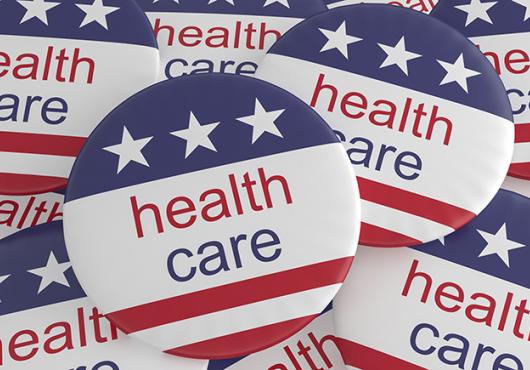 Multiple political buttons with U.S. flag and health care printed on them