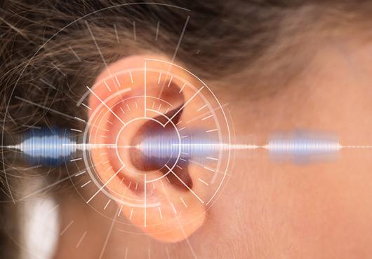 Close up of a white child's ear with a sound wave overlaid digitally
