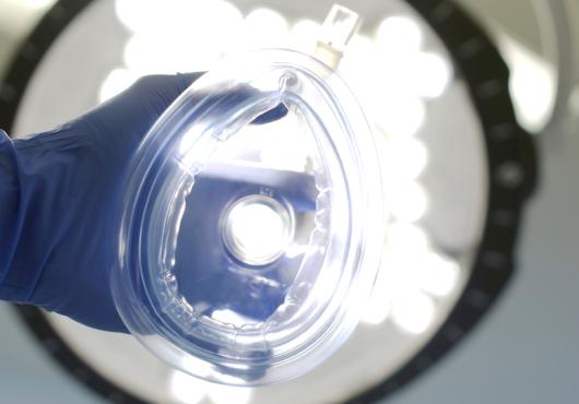 anesthetic mask held toward camera as if being put on the viewer