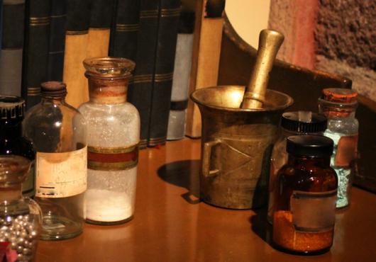 Antique medication bottles, mortar and pestle, and powders