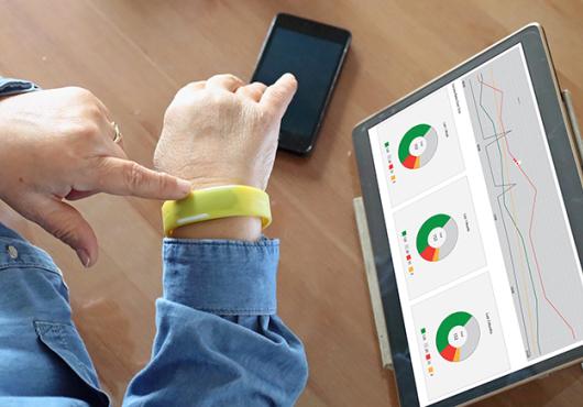 woman's wrist with smart watch and tablet with health data