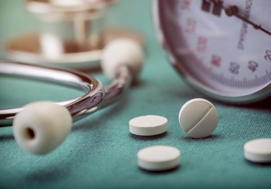 stock image of blood pressure cuff and pills with stethoscope