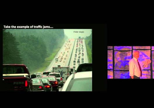 Juan Enriquez points to a picture of traffic