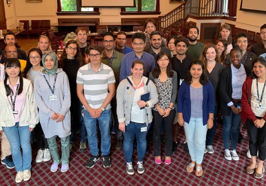 Group of diverse young people posing for photo in a meeting room