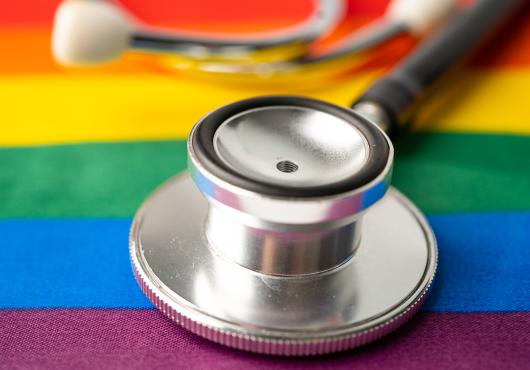 A stethoscope rests on a table covered with  rainbow-colored cloth.