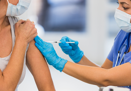 A person administers a COVID vaccine