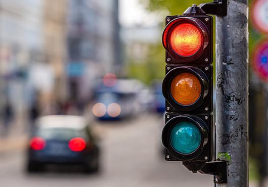 Photo of traffic signal on red, city street blurred out in background