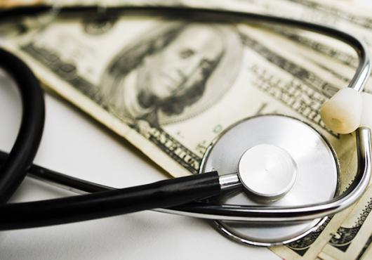 photo of stethoscope on top of money
