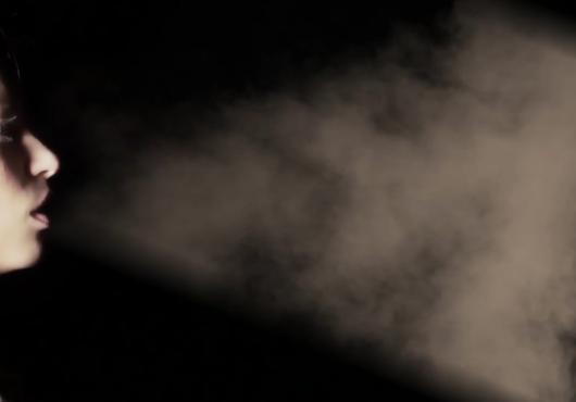 A girl blows smoke