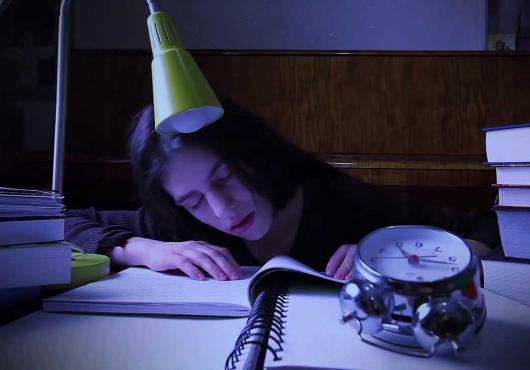 A girl falls asleep at her desk