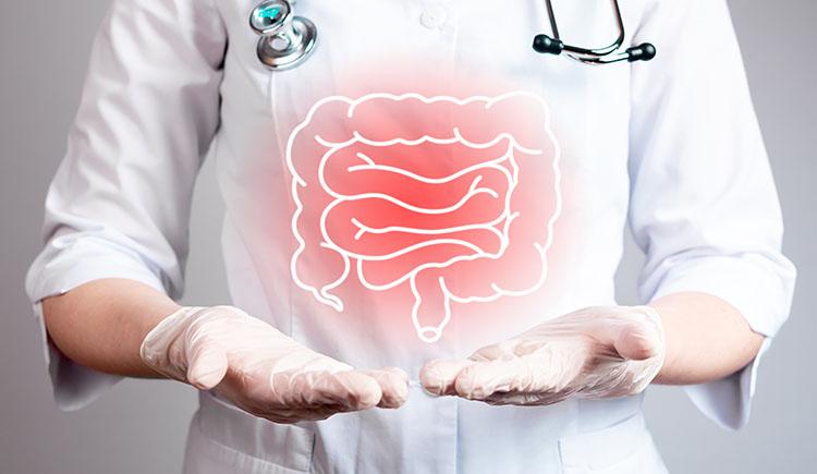 A human figure in a white coat, gloves, and stethoscope points to inflamed colon