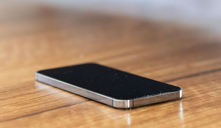 A phone with screen off sitting on a table