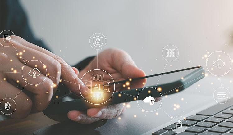 photo of a user looking at a smartphone screen in front of a computer