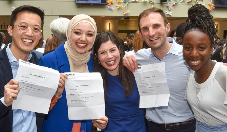 A group of 3 HMS medical students and two of their friends celebrate showing their Match Day letters. Image: Steve Lipofsky
