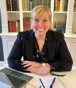 Julie Joncas, Chief Financial Officer of Harvard Medical School sitting at her office desk with a computer in front of her.