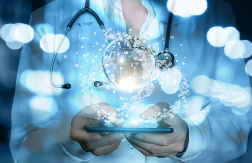 torso of a physician in a white coat and stethoscope draped around their neck holding a tablet with a clear globe floating above it