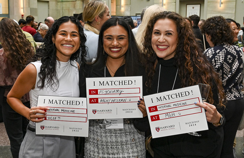 Three grinning students with long hair hold signs that say "I Matched!" with details of where they will pursue their residency training