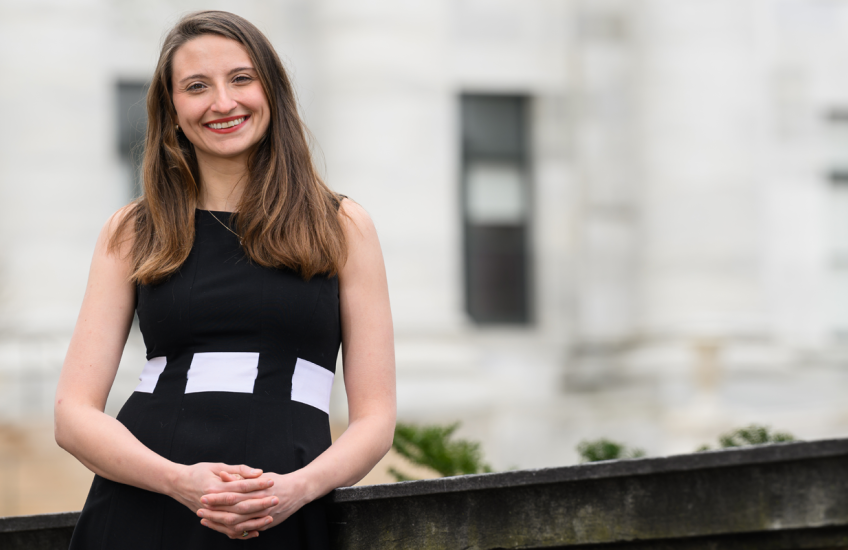 Plana outside in black and white dress with Quad building blurred behind