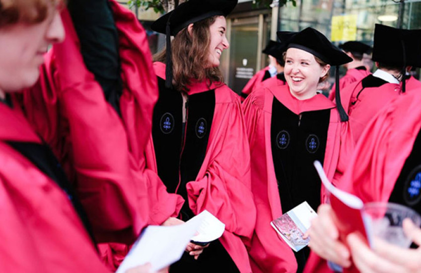 candid photo of group of PhD graduates wearing caps and gowns