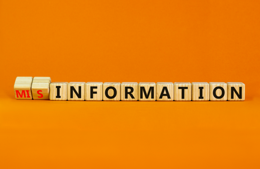 Children's blocks reading "misinformation" on an orange background