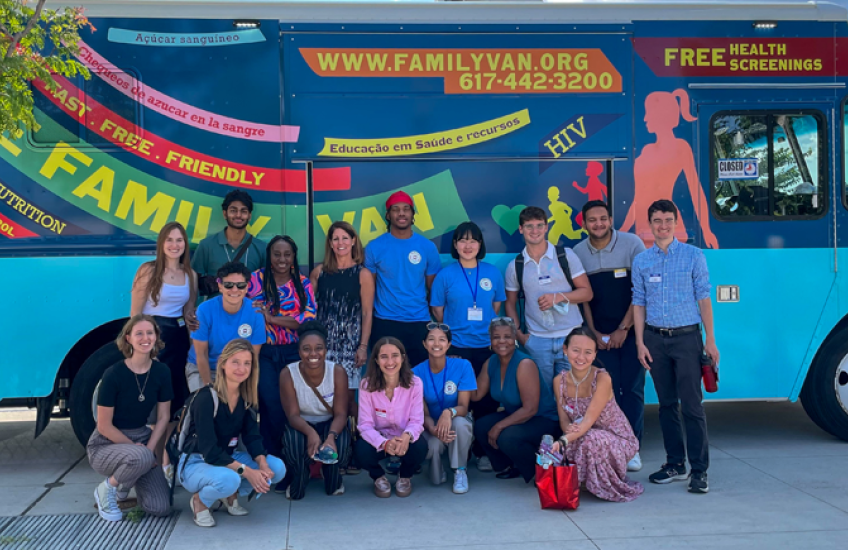 A group of medical students and staff in front of a colorful van