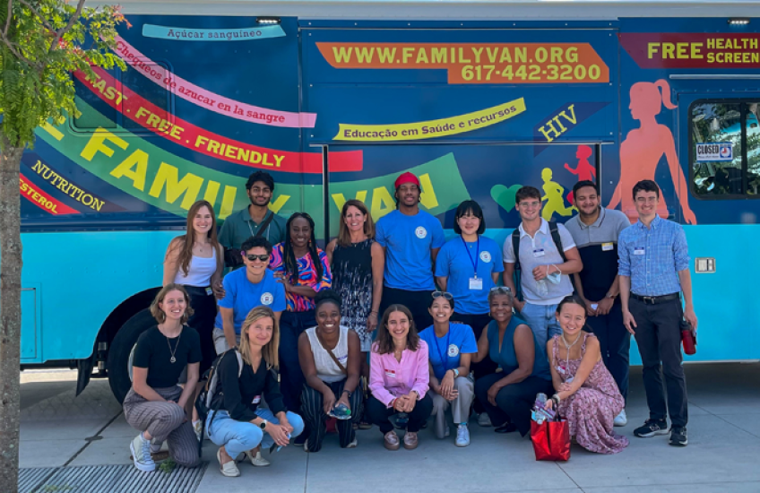 Group of medical students and staff in front of a colorful van