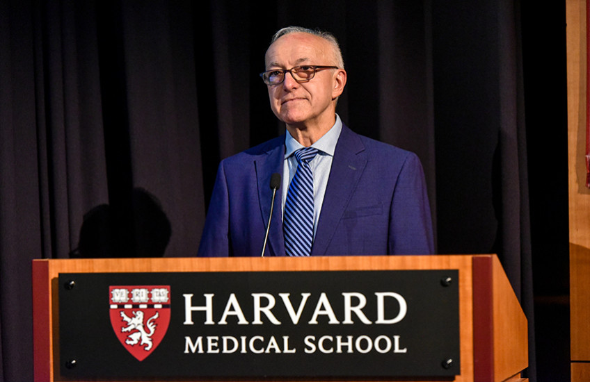 Dean George Q. Daley stands behind a Harvard Medical School podium